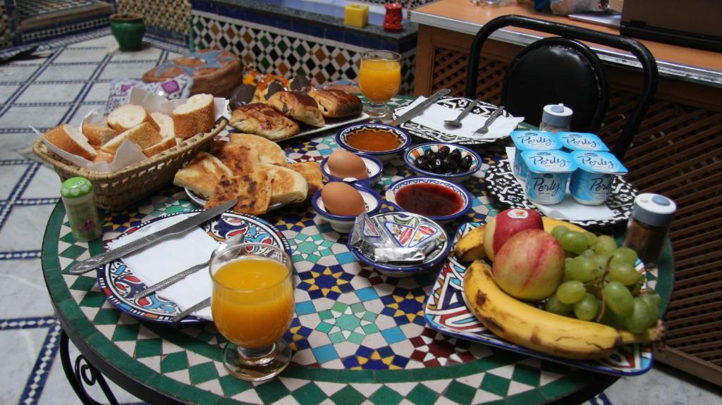 uma mesa com uma bandeja de comida e fruta em Riad Fez Qamar em Fez