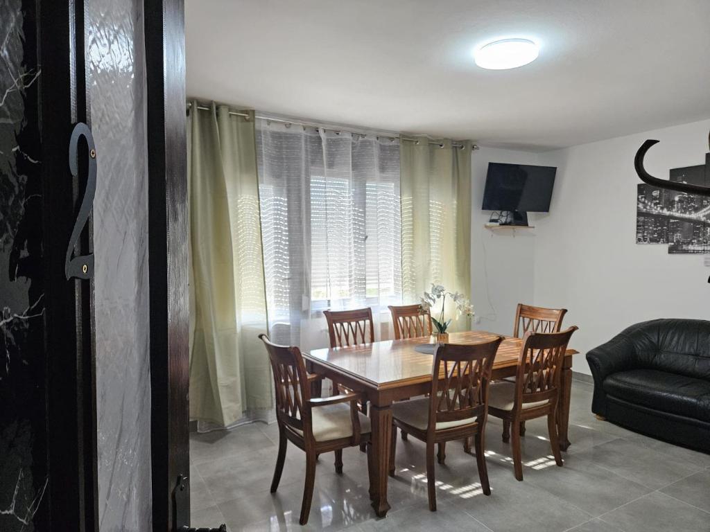 ein Esszimmer mit Tisch und Stühlen und einer Couch in der Unterkunft Kuća za odmor Antunović in Habjanovci