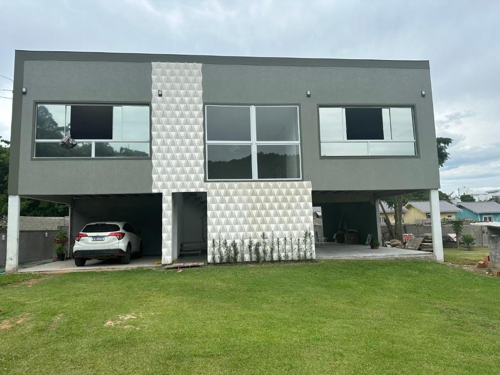 ein Haus mit einem davor geparkt in der Unterkunft Residencial Valentina Jurere in Florianópolis
