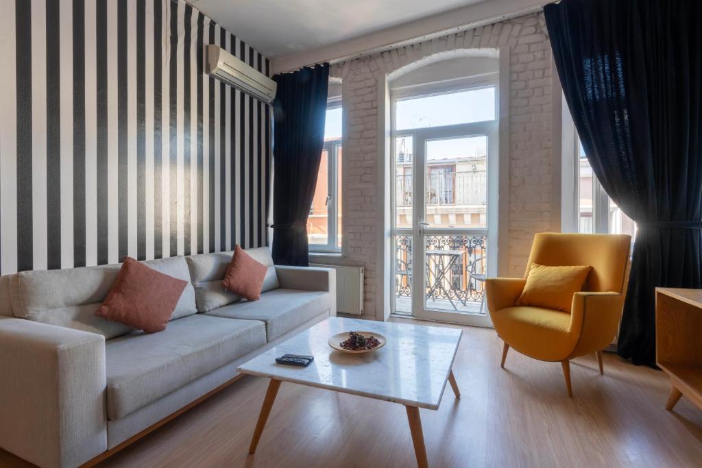 イスタンブールにある5 Apartment Galataのリビングルーム(ソファ、テーブル、椅子付)