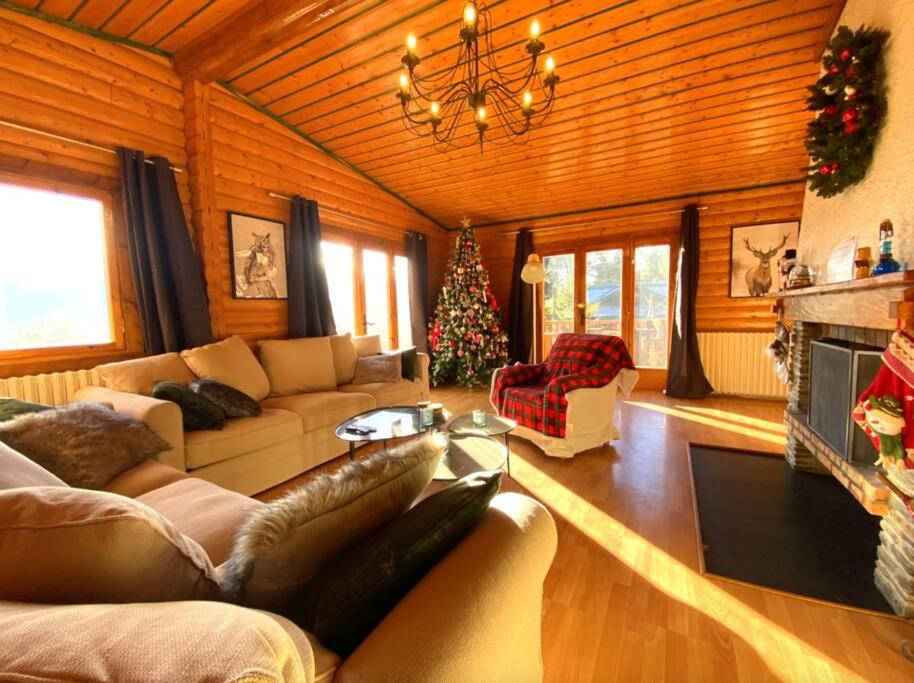 sala de estar con sofá y árbol de Navidad en Chalet Vue Panoramique en Bolquere Pyrenees 2000