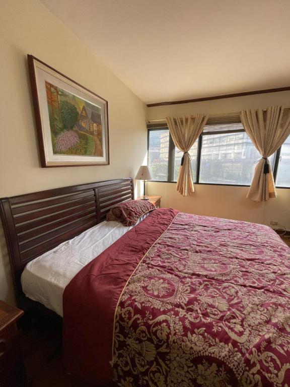 馬尼拉的住宿－Spacious Luxury 3BR at the Heart of Makati，一间卧室设有一张大床和两个窗户。