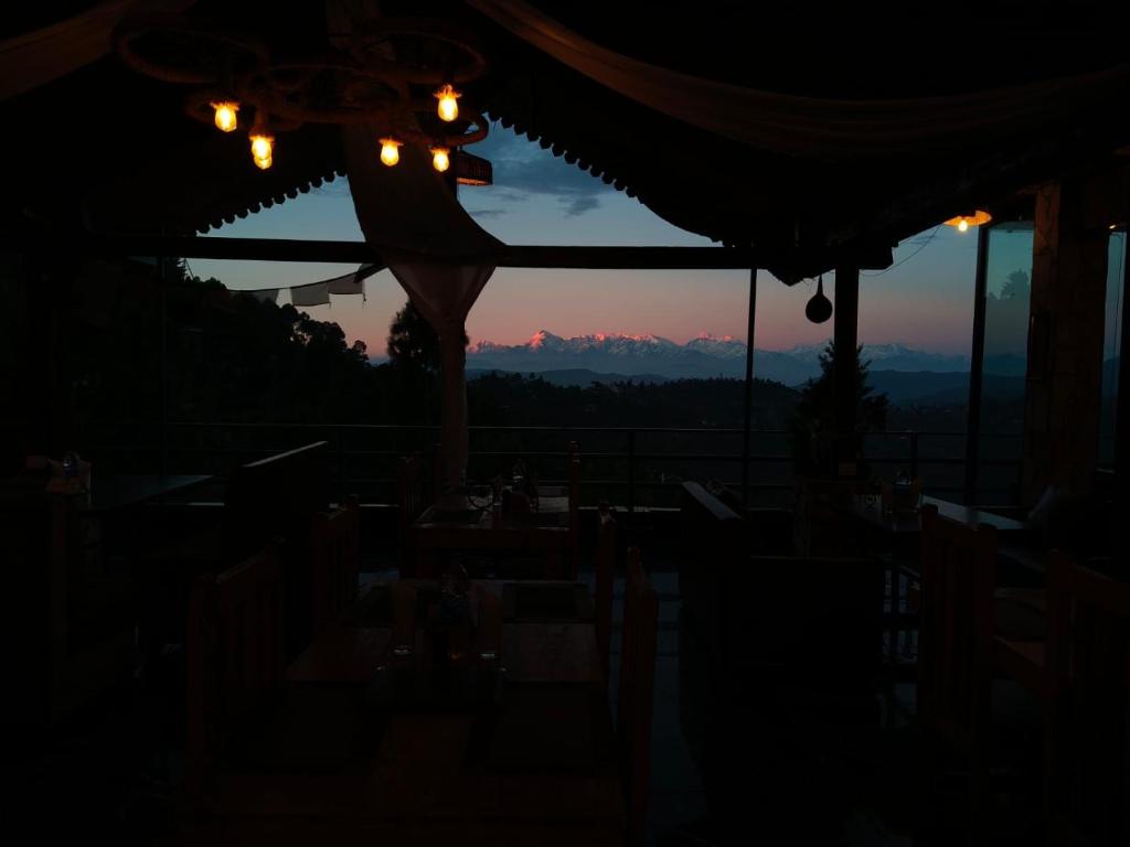 阿爾莫拉的住宿－The Himalayan Heights Satya's kasardevi，晚上,客人可以在餐厅欣赏山景