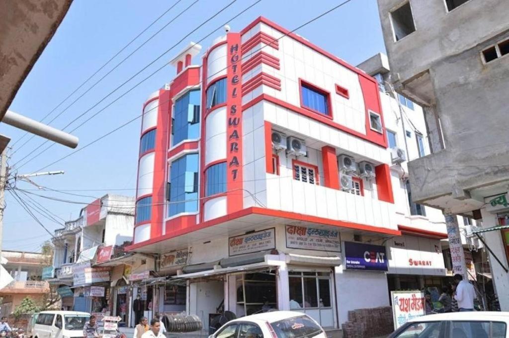 czerwono-biały budynek przy ulicy miejskiej w obiekcie Hotel Swarat By BookingCare w mieście Satna