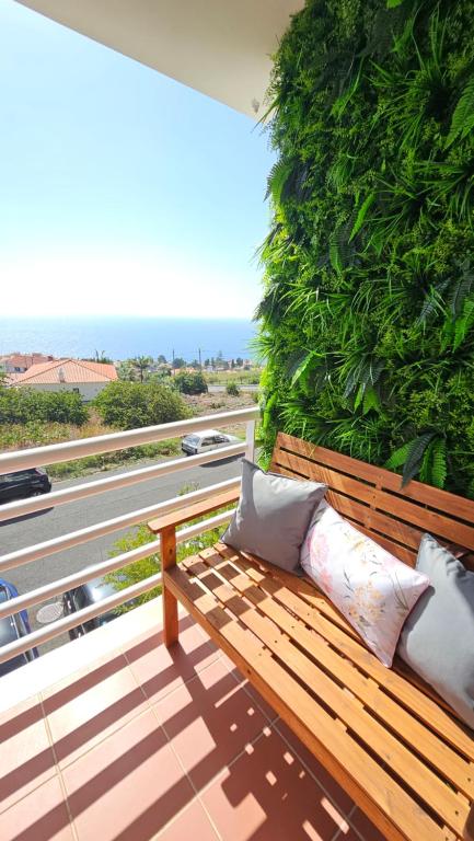 un banc en bois installé au-dessus d'un balcon dans l'établissement Seaview Relax Apartment, à Caniço
