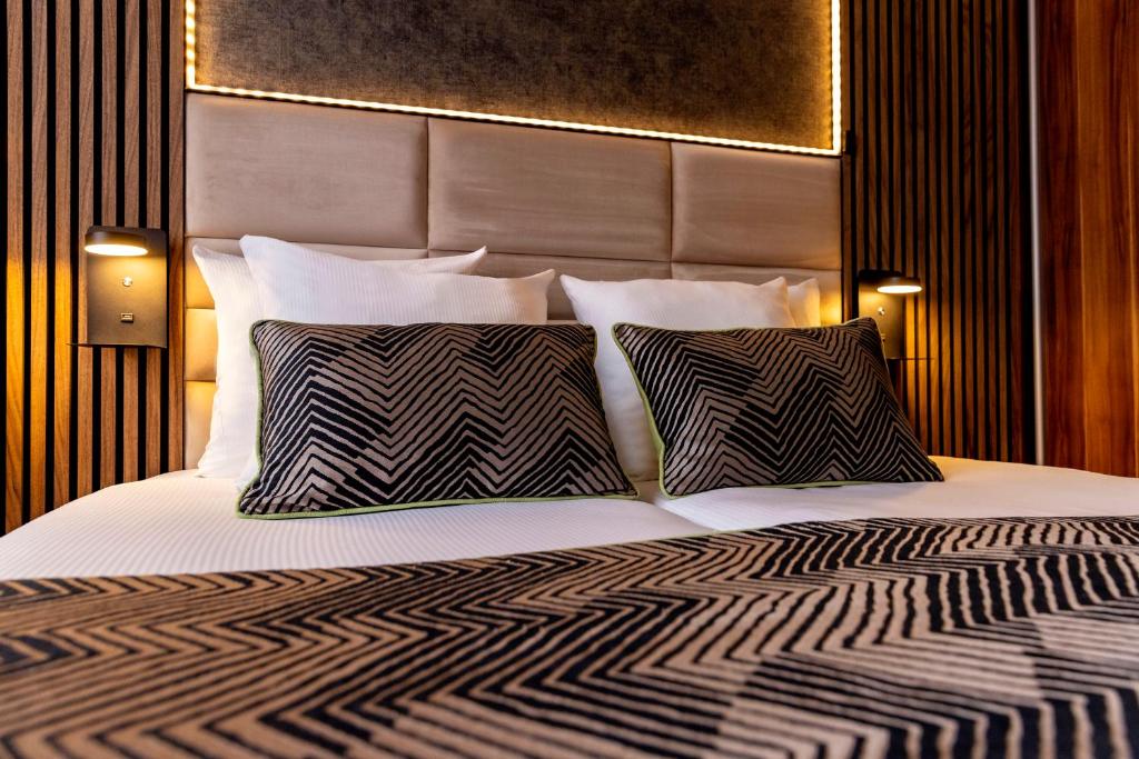 um quarto com uma cama grande e 2 almofadas em Jupiter Hotel em Amsterdã