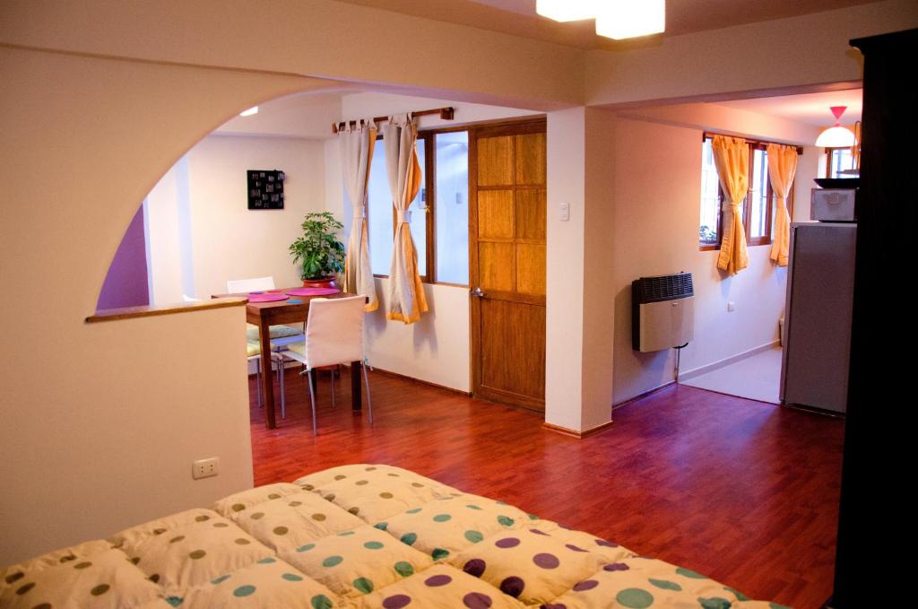 a bedroom with a bed and a table and a kitchen at Historical Center Apartments in Cusco
