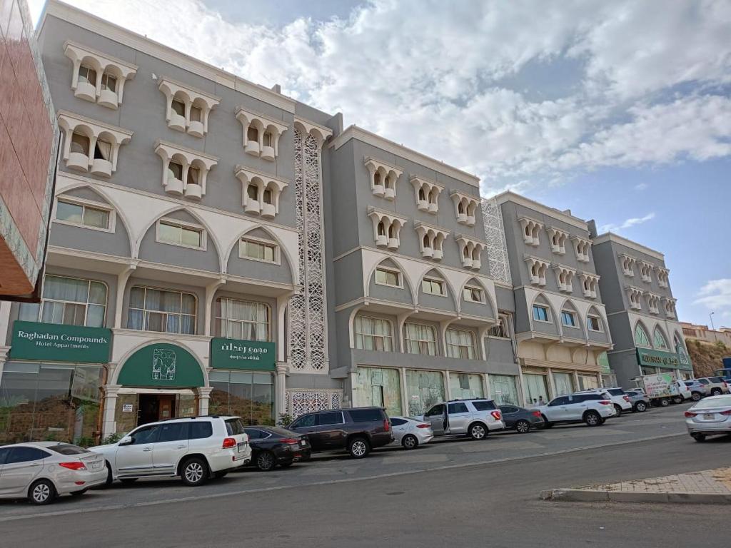 rząd budynków na ulicy z zaparkowanymi samochodami w obiekcie مجمع رغدان السياحي w mieście Al-Baha