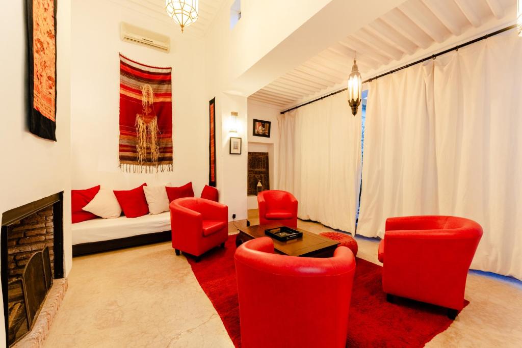 a living room with red chairs and a couch at Riad Rouge Gorge in Marrakesh