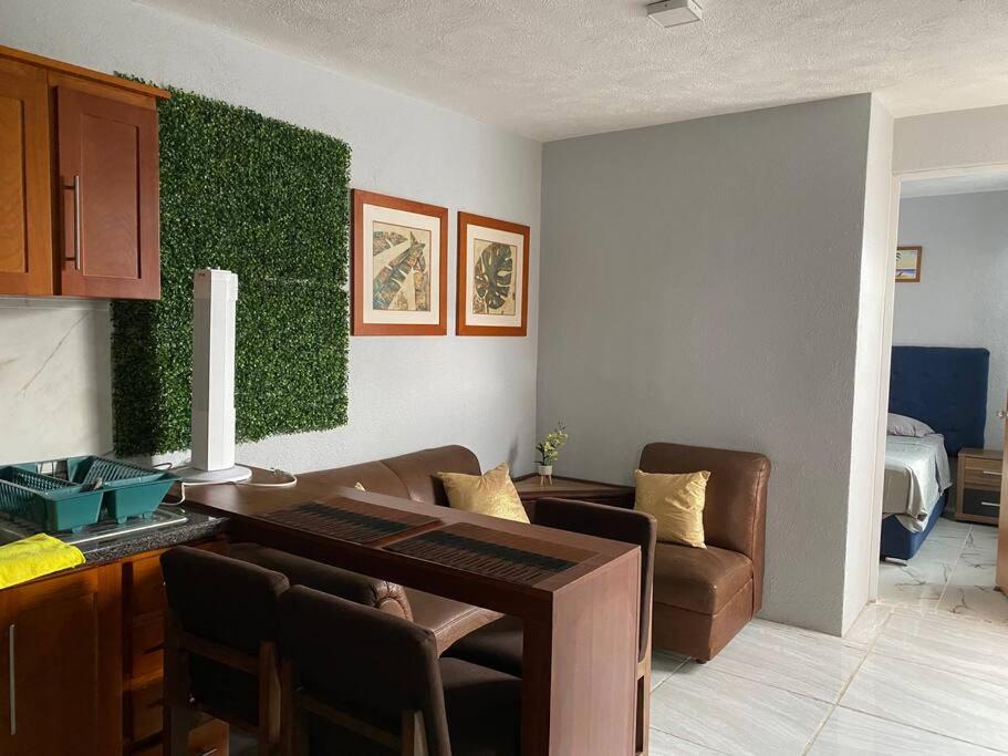 sala de estar con mesa y pared verde en Casa duplex aeropuerto/arena VFG, en Guadalajara