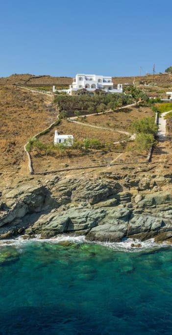 an aerial view of the ocean with houses on a cliff at La Chapelle Ouest & Grand suite in Agios Romanos