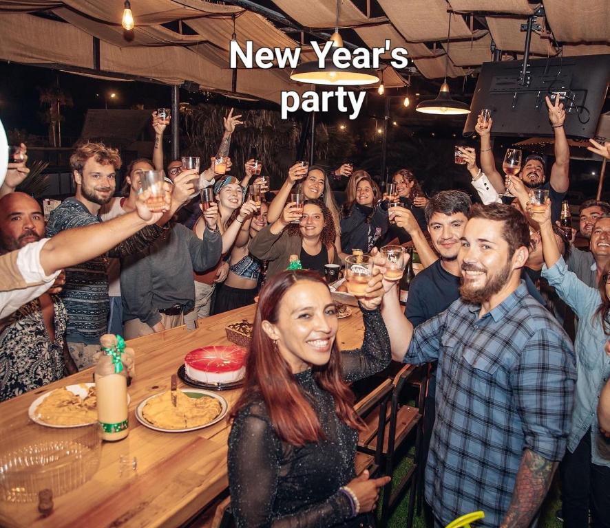 a group of people raising their glasses at a new year party at Hostel Willka Kuti Backpackers in Arica