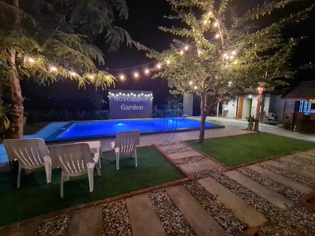 a backyard with a table and chairs and a pool at November Garden ชัยนาท 