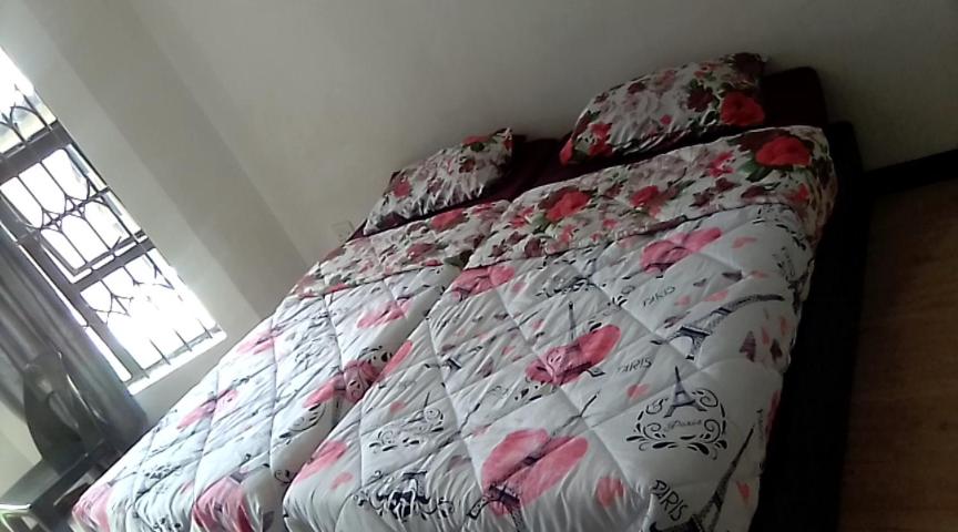 een bed met een bloemdekbed in een slaapkamer bij Inspire living in Benoni