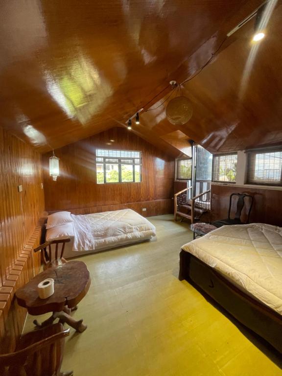 een slaapkamer met 2 bedden en een bureau in een kamer bij Lovely Villa in Tagaytay with Pool & Full Taal View in Tagaytay