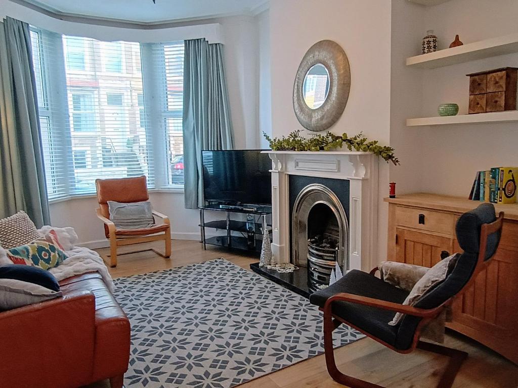 a living room with a fireplace and a tv at 4 Bed house Sea Views Benji's by the beach in Morecambe