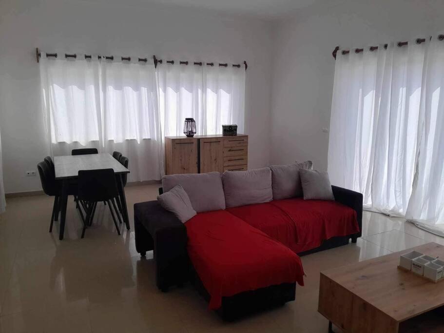 salon z czerwoną kanapą i stołem w obiekcie Christian’s Villa w mieście Cidade Velha