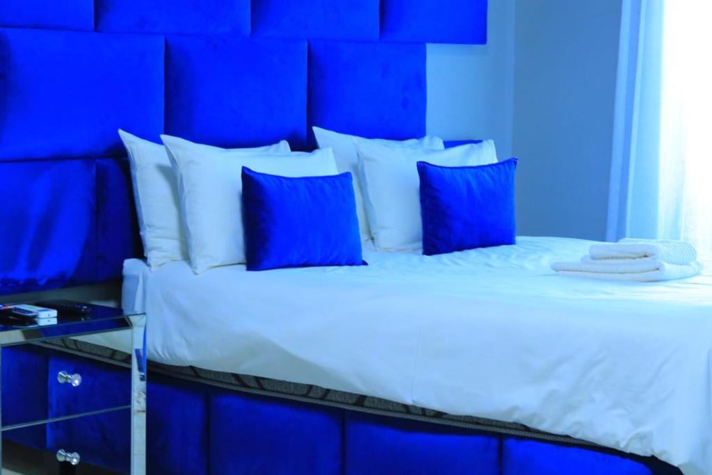 - une chambre bleue avec un grand lit et des oreillers bleus dans l'établissement La Maison Guesthouse, à Thohoyandou