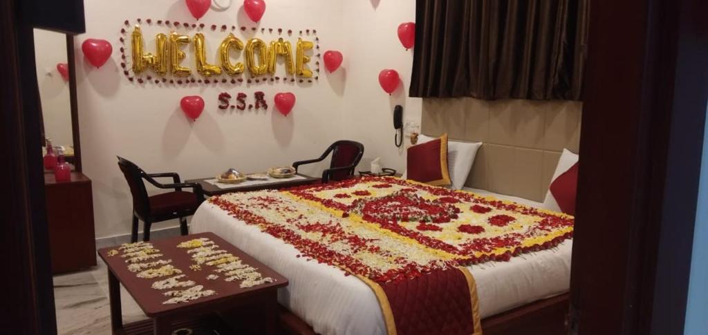 Un dormitorio con una cama y una mesa con corazones en la pared. en Hotel Sri Sai Residency, en Khammam