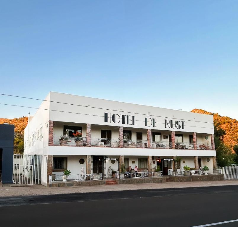 un hotel di ruggine sul lato di una strada di Hotel De Rust a De Rust