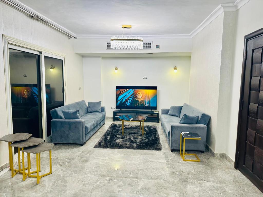 uma sala de estar com 2 sofás e uma televisão de ecrã plano em Modern Comfy Flat no Cairo