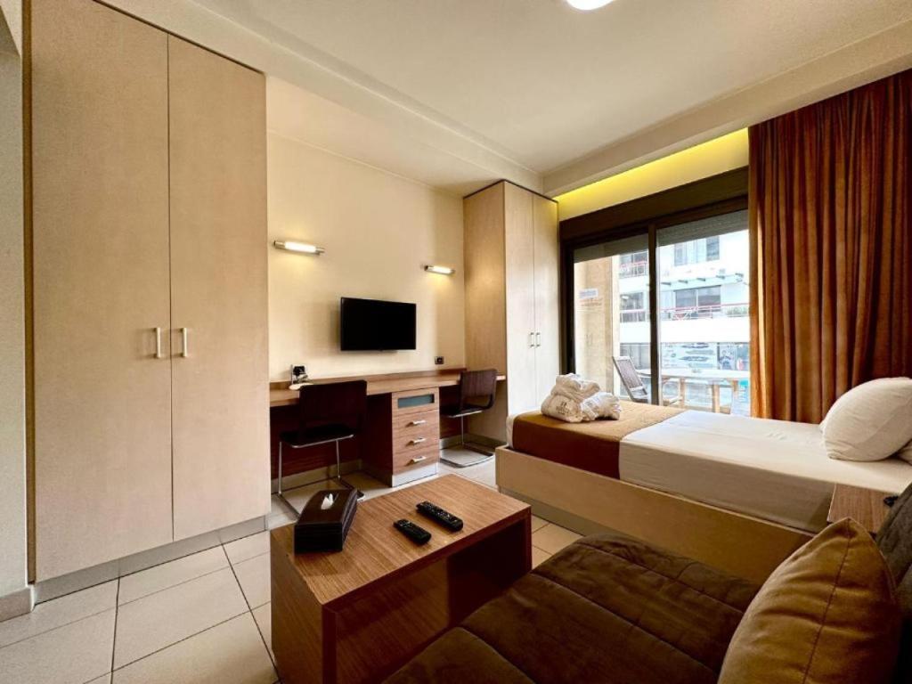 a hotel room with a bed and a tv at Karl s Single Room with Gym and Bar in Jounieh