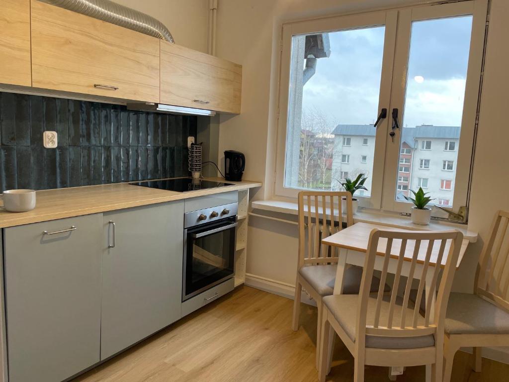 a kitchen with a table and a table and chairs at P15 in Suwałki