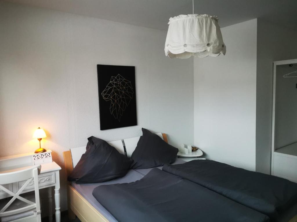 a bedroom with a bed and a desk with a lamp at Ferienwohnung Flüburg in Diemelstadt 