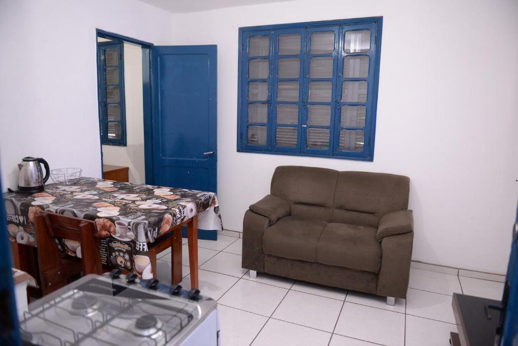 ein Wohnzimmer mit einem Stuhl und einem Tisch in der Unterkunft Apto c Wifi e otima localizacao em Santa Rosa RS in Santa Rosa
