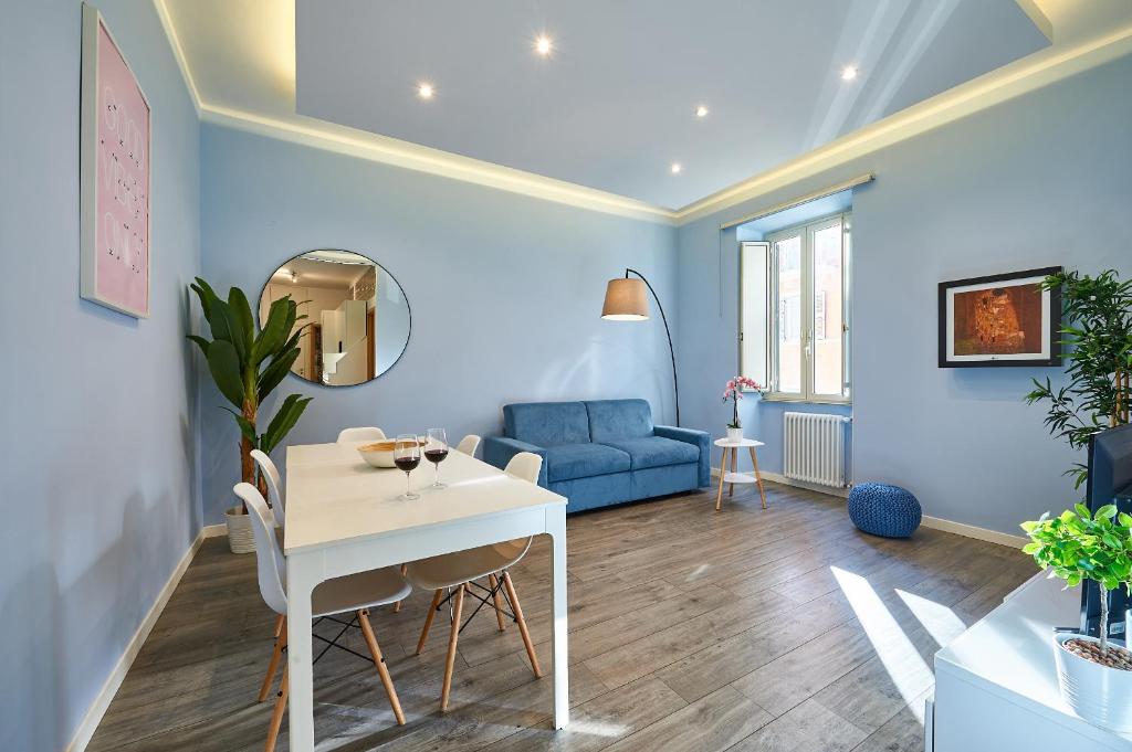 - un salon avec une table et un canapé bleu dans l'établissement Good Vibes Rome comfort and quality, à Rome