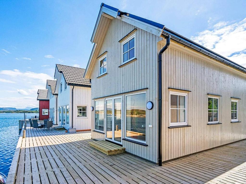 a building on a dock next to the water at Holiday home Averøy VII in Karvåg