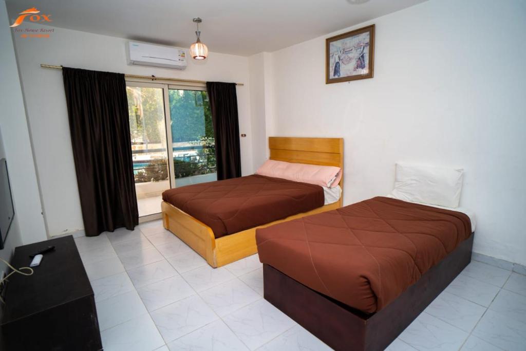 - une chambre avec 2 lits et une fenêtre dans l'établissement ELCAPTION RESORT, à Hurghada