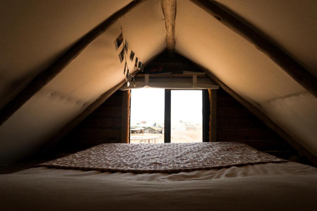 a bed in a tent with a window at Salty House Cabo Polonio in Cabo Polonio
