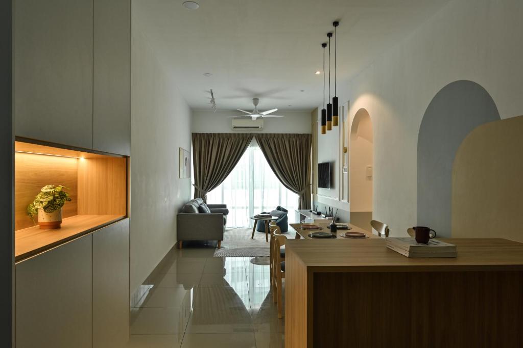 a kitchen and a living room with a table at Razak City Residence in Kuala Lumpur