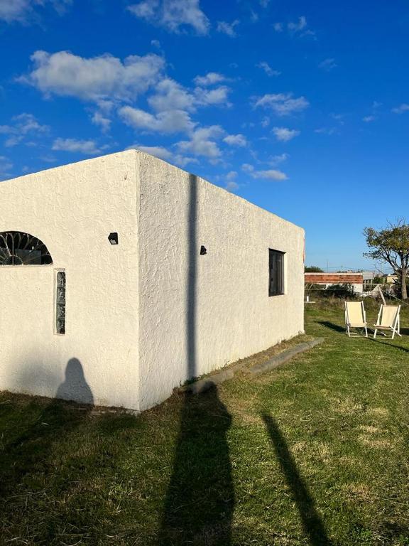a white building with a shadow on the side of it at Casa en punta N a 12 minutos de Piriapolis in Punta Colorada