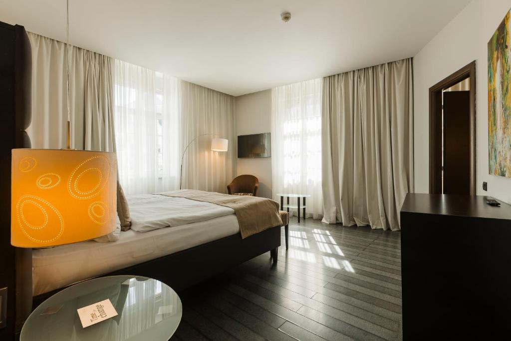une chambre d'hôtel avec un lit et une table en verre dans l'établissement Hotel Timisoara, à Timişoara