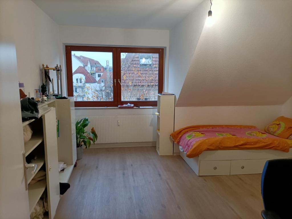 ein kleines Schlafzimmer mit einem Bett und einem Fenster in der Unterkunft Bahnhof in Bielefeld