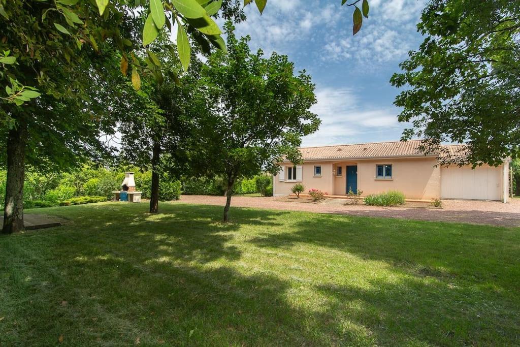 a house with a yard with trees in front of it at Gîte Le 31 Bis, en centre ville avec jardin. in Blaye