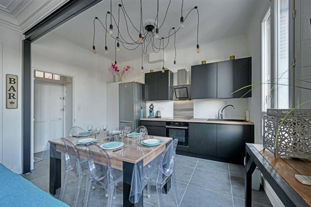 a dining room with a table and a kitchen at The Rooftop - AC CLIM - Wi-Fi - Parking gratuit dans la rue in Avignon