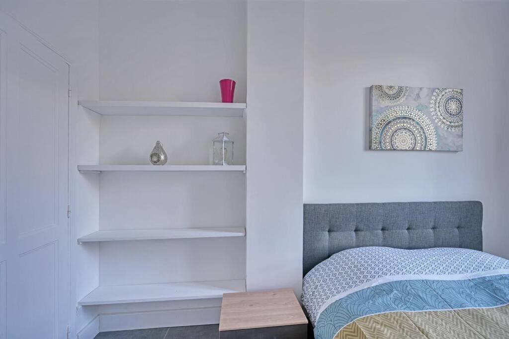 a bedroom with white walls and a bed and shelves at The Rooftop - AC CLIM - Wi-Fi - Parking gratuit dans la rue in Avignon