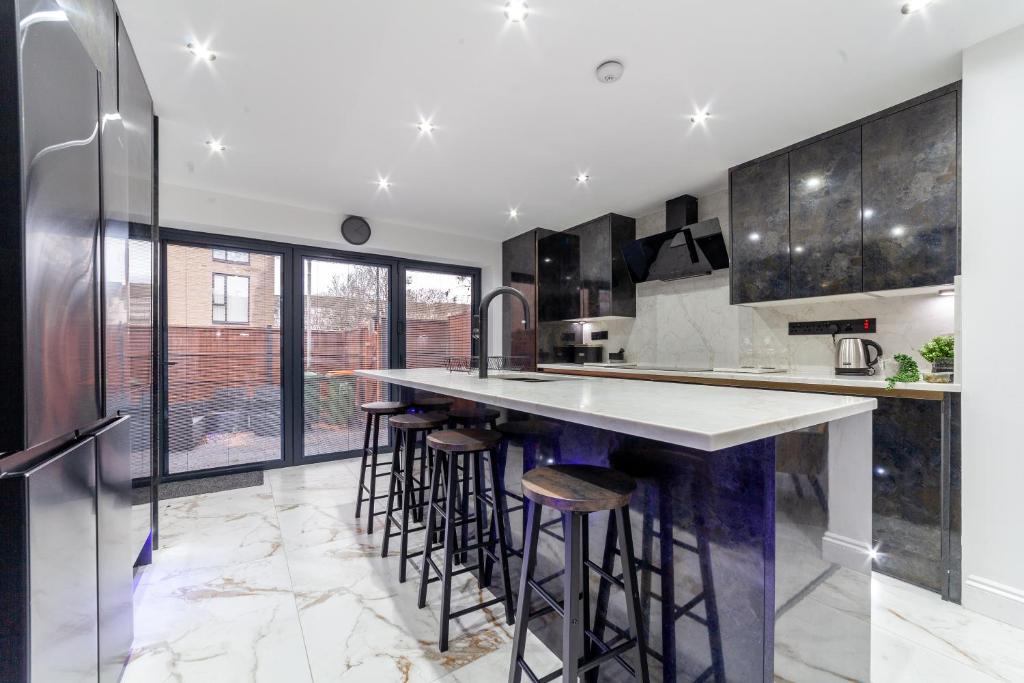 a kitchen with a large island with bar stools at Home from Home in London