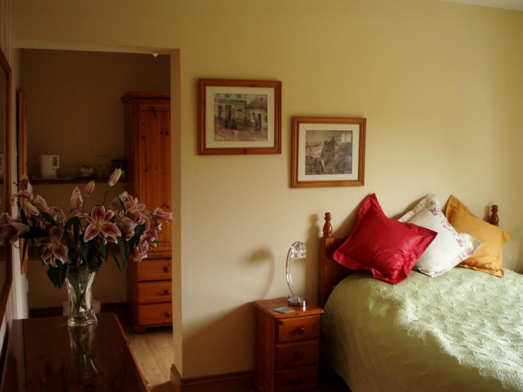 a bedroom with a bed and a vase of flowers at The Burn in Cushendall