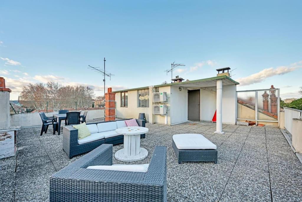 a patio with couches and tables on a roof at The Rooftop - AC CLIM - Wi-Fi - Parking gratuit dans la rue in Avignon