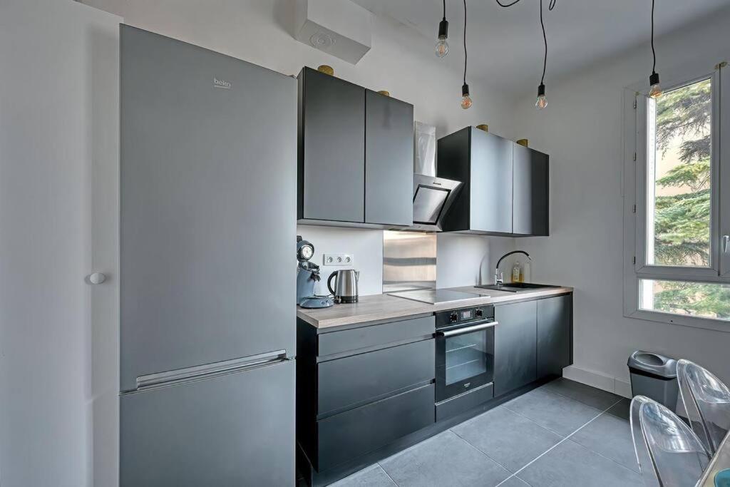 a kitchen with stainless steel appliances and a refrigerator at The Rooftop - AC CLIM - Wi-Fi - Parking gratuit dans la rue in Avignon