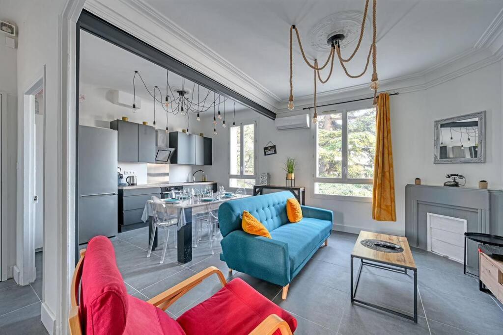 a living room with a blue couch and a kitchen at The Rooftop - AC CLIM - Wi-Fi - Parking gratuit dans la rue in Avignon