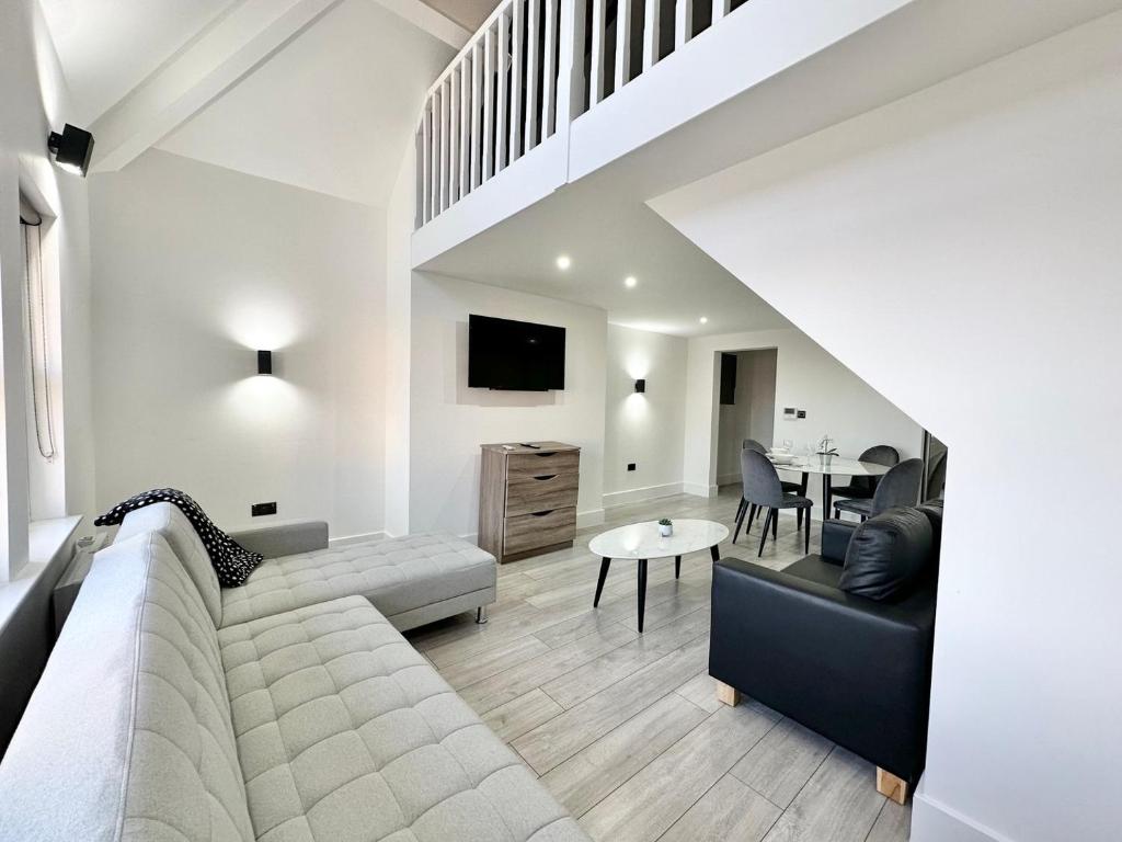 a living room with a couch and a table at Luxury Duplex City Centre Apartment in Leeds