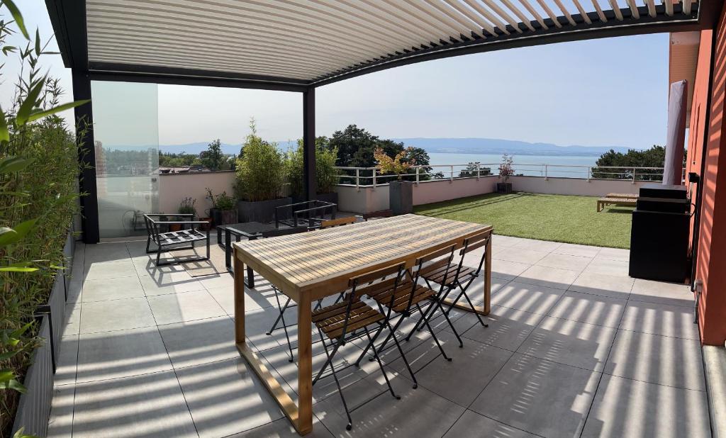 エヴィアン・レ・バンにあるIMMODREAMS - L'Attik with lake views and 80m2 terraceのパティオ(テーブル、椅子付)