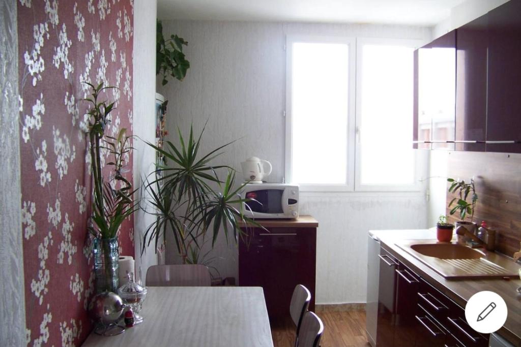 een keuken met een tafel, een wastafel en een raam bij Elégant apparemment 60m2 climatisé in Avignon