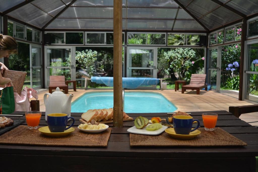 uma mesa com comida e bebidas junto a uma piscina em La Foresta em Rincón del Pino