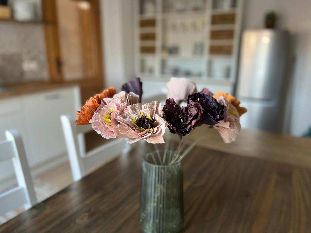 un jarrón lleno de flores sentado en una mesa en Ferienwohnung Peters (EG), en Hünfeld